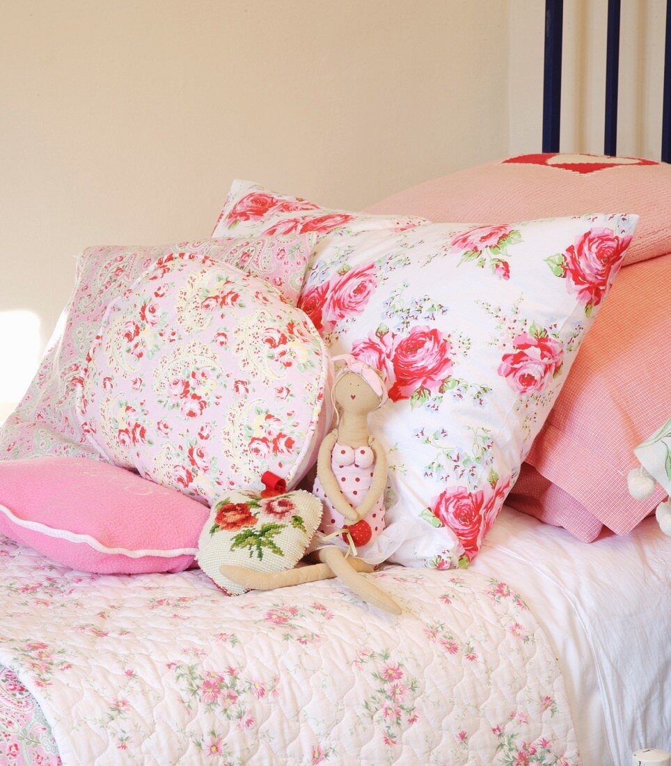 Blumenmuster auf verschieden grossen Kissen auf Bett in ländlichem Stil