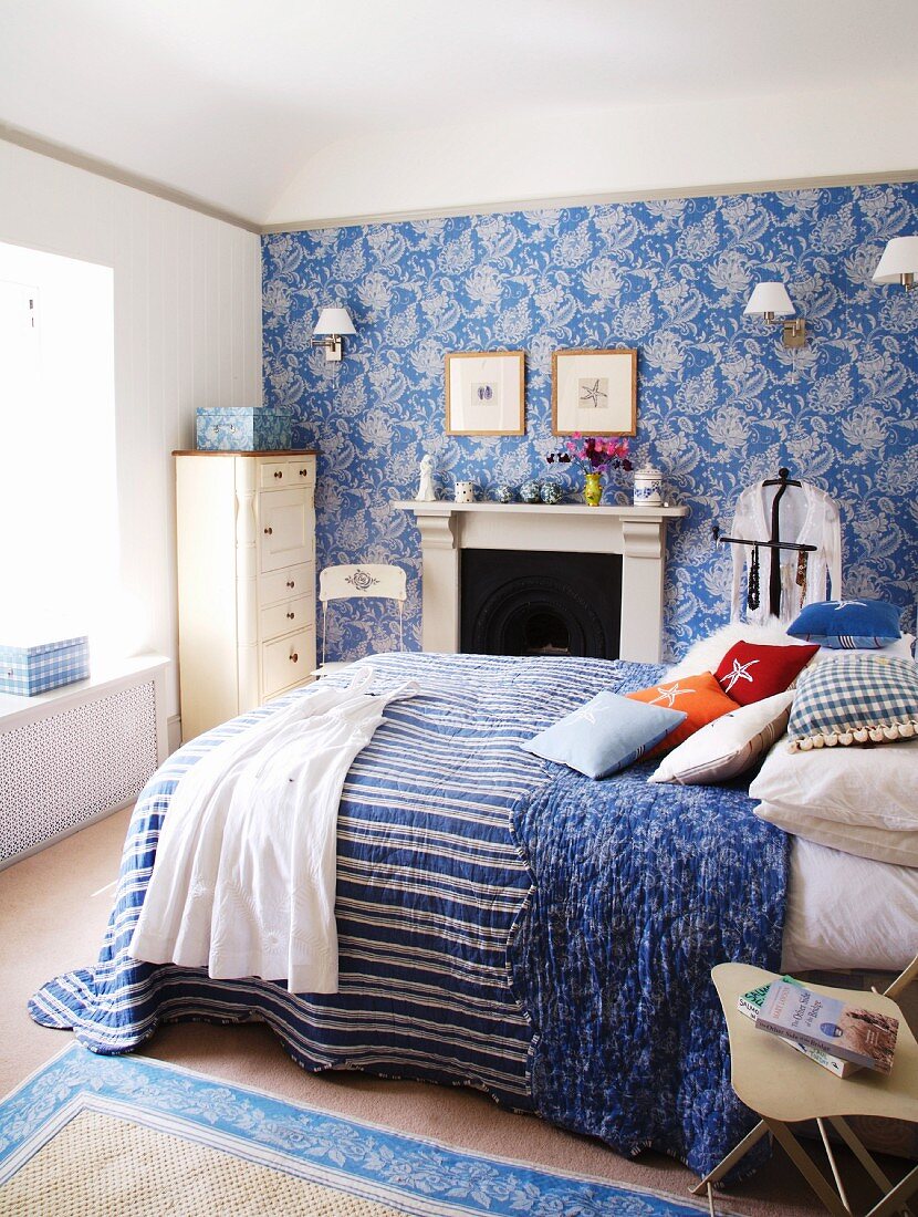 Ländliches Schlafzimmer in Weiß und Blau mit Doppelbett vor Kamin