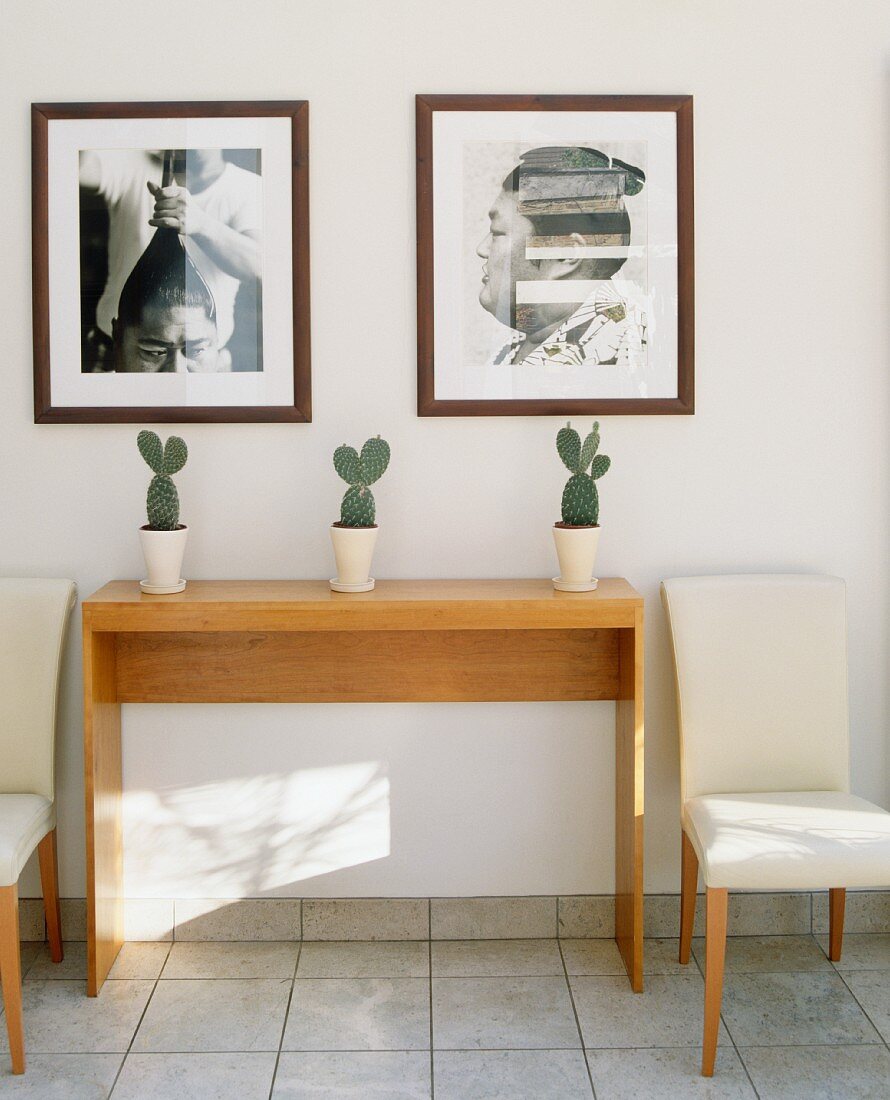Flurbereich mit Konsolentisch aus Holz, zwei Polsterstühlen & Wandbildern