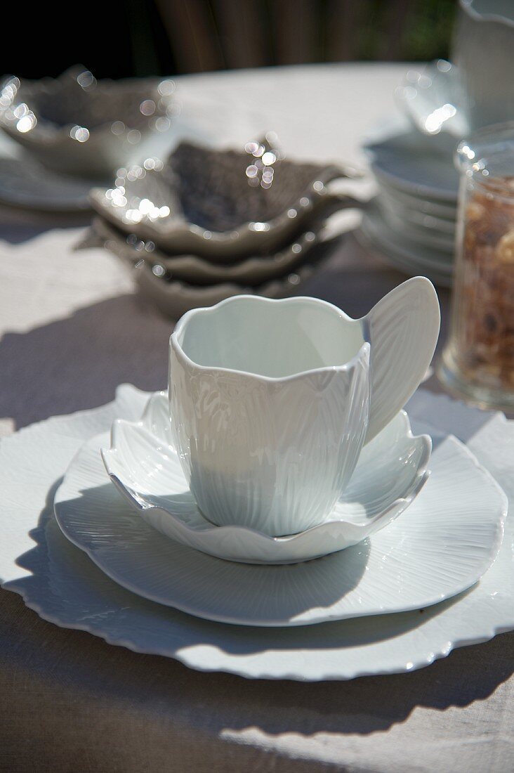 White, designer china teacup with matching saucer and plate
