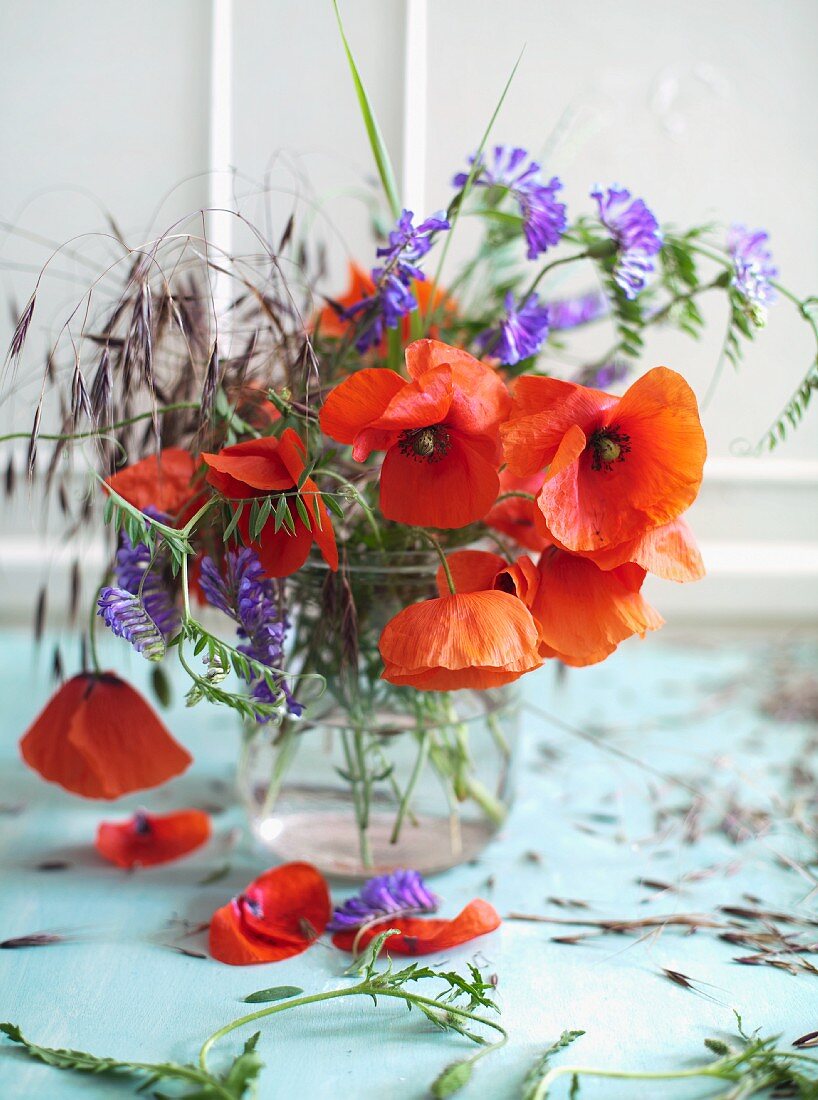 Wildflower posy with poppies in drinking glass