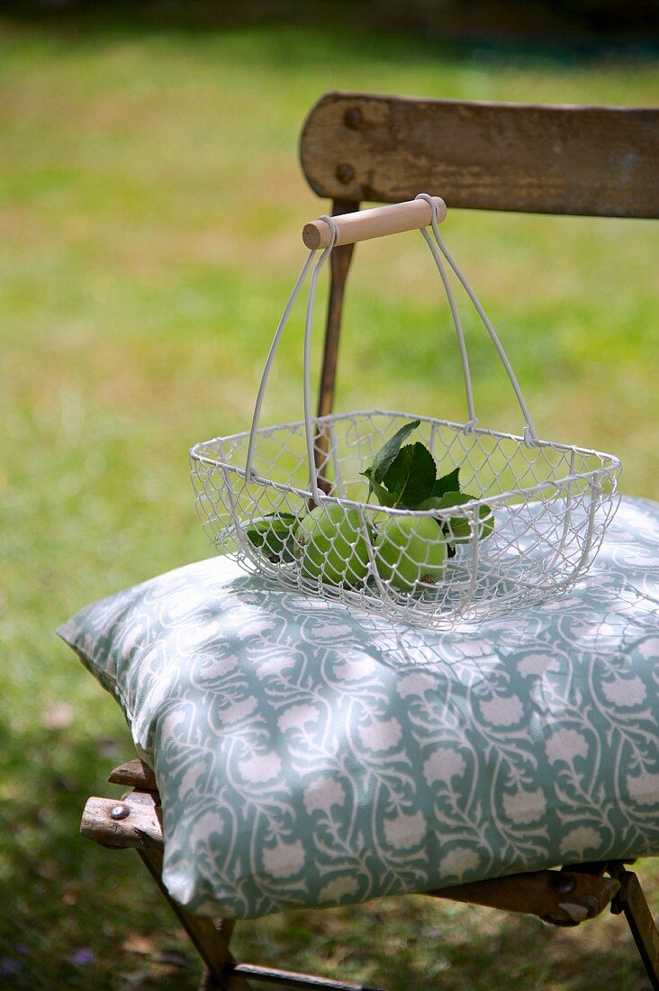 Garden chair with cushion & apples in basket