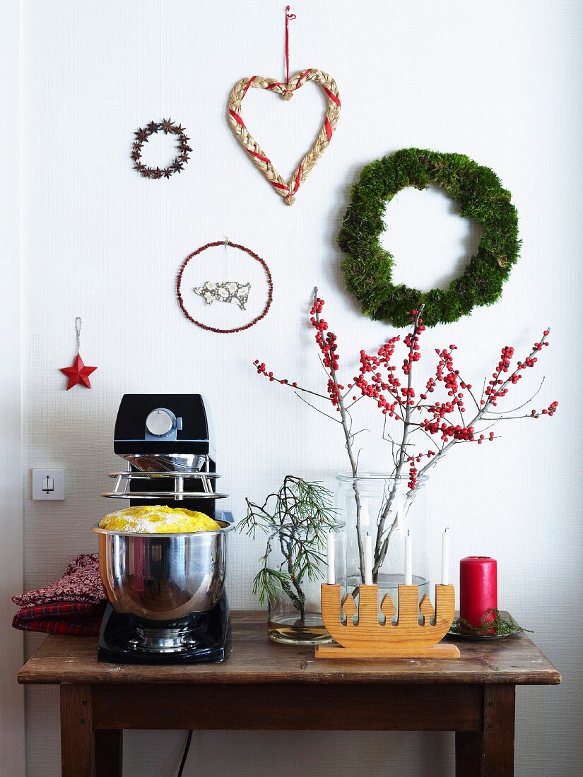 Küchenmaschine mit Teig und Weihnachtsdekoration auf einem Wandtisch