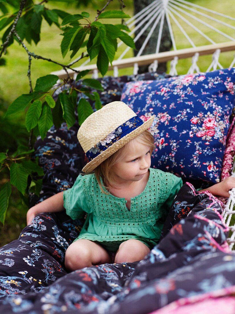 Girl wearing straw hat on hammock
