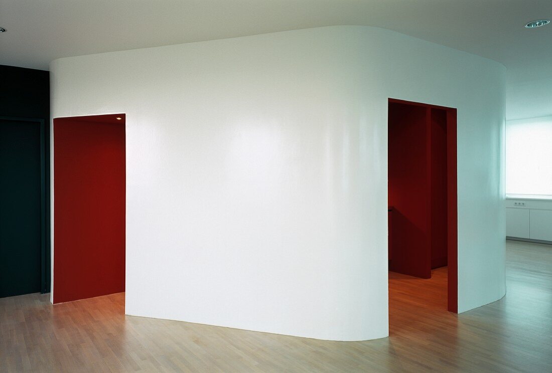 Installation with rounded corners and view through open doorways into red-painted interior