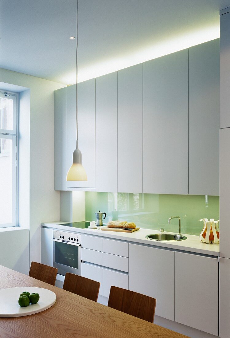 Moderne Küche mit weissen Schränken und indirektem Licht