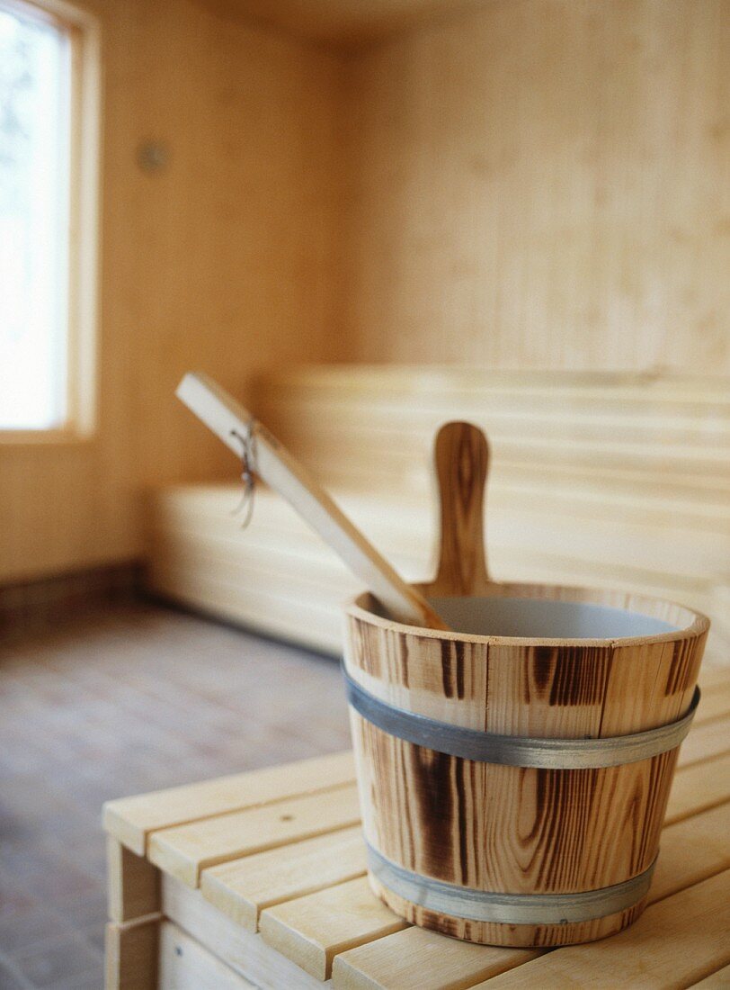 Small wooden tub on wooden bench in home sauna