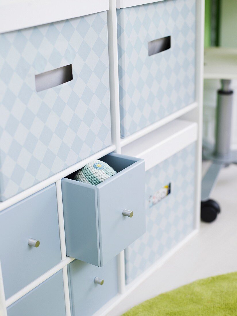Ample storage space in grey patterned boxes and small drawers in cabinet