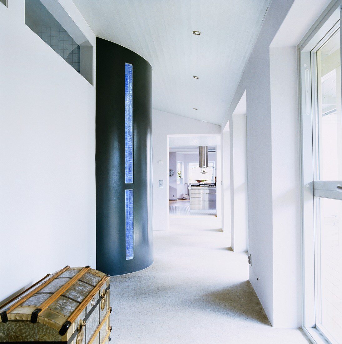 Semicircular protrusion with blue glass strip in corridor with windows along one side