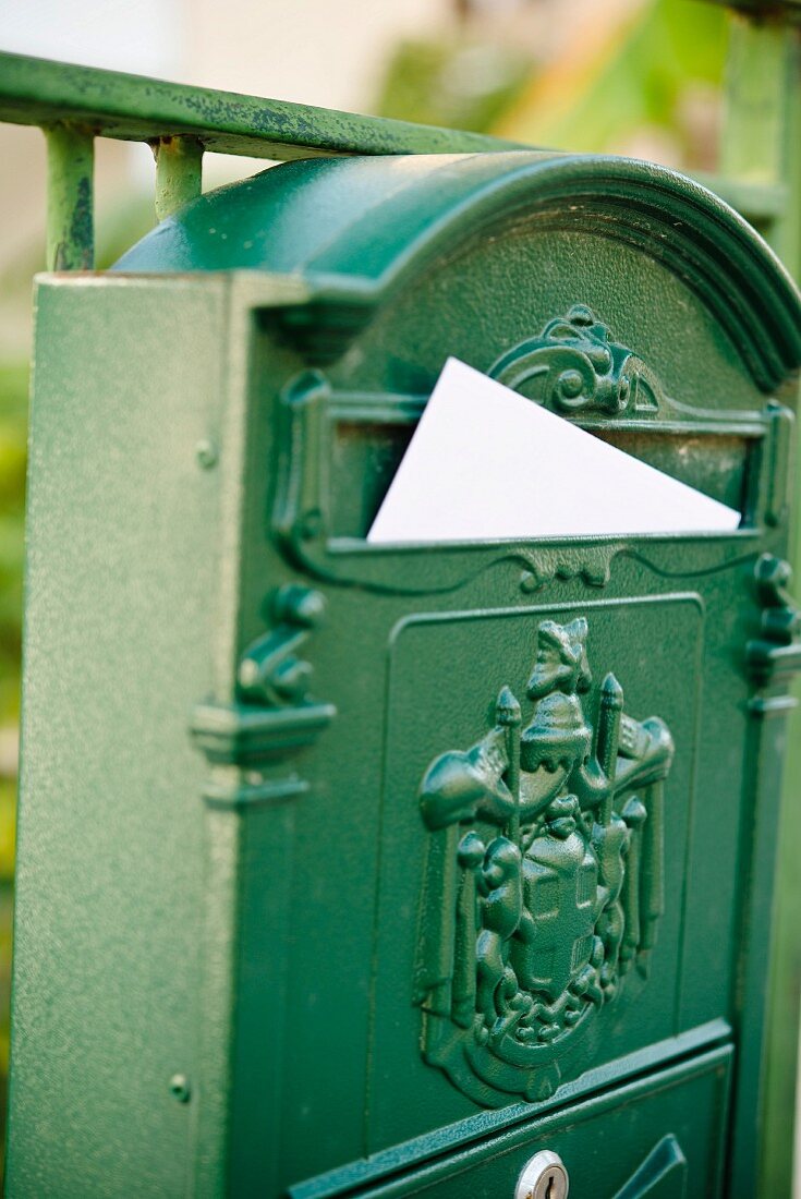 Vintage Briefkasten aus grün lackiertem Metall mit eingeschobenem Brief