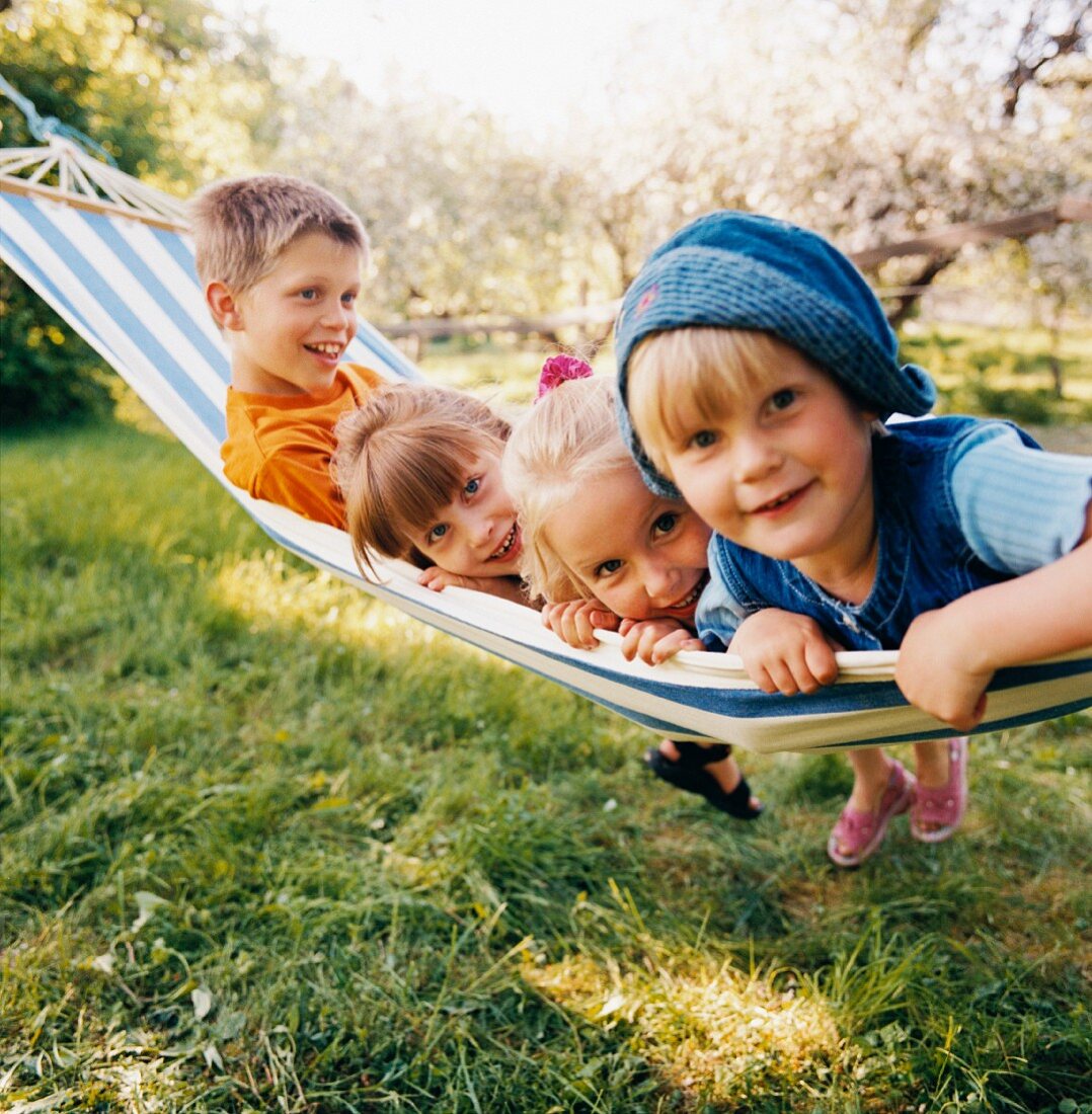 Vier Kinder auf einer Hängematte im Garten
