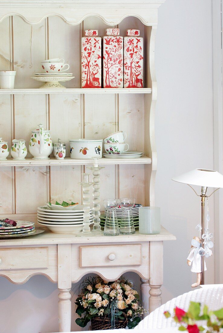 Crockery and ceramic vessels in rustic dresser with open-fronted top
