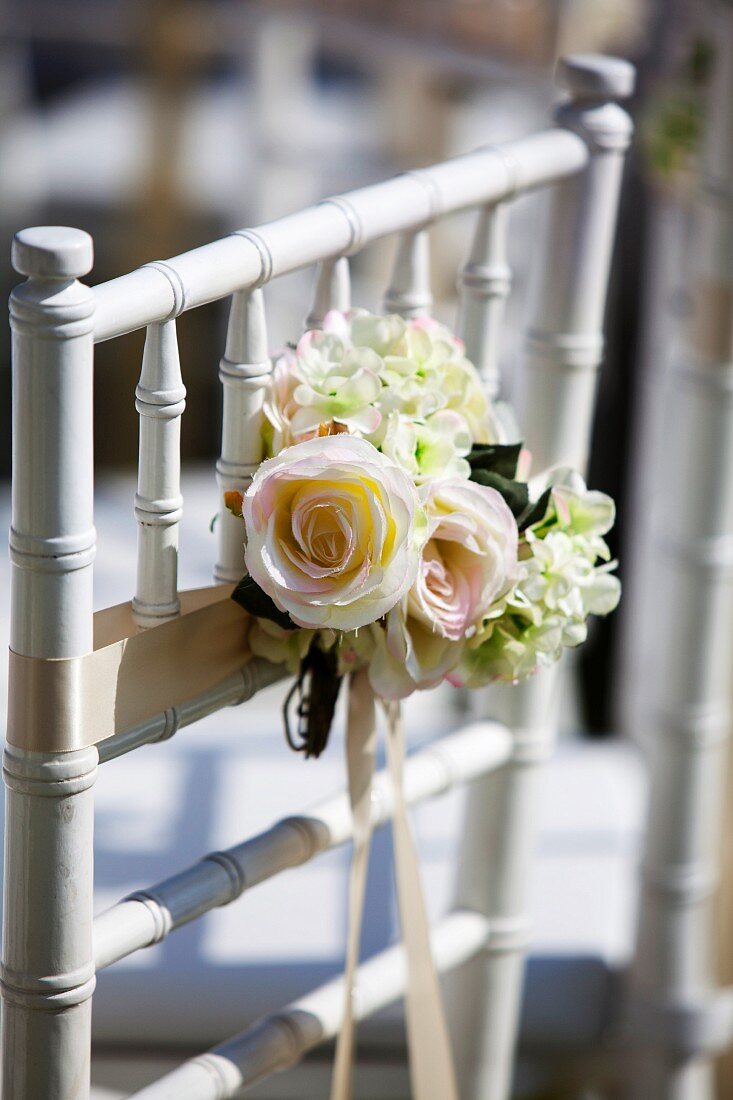 Posy of roses tied to chair back