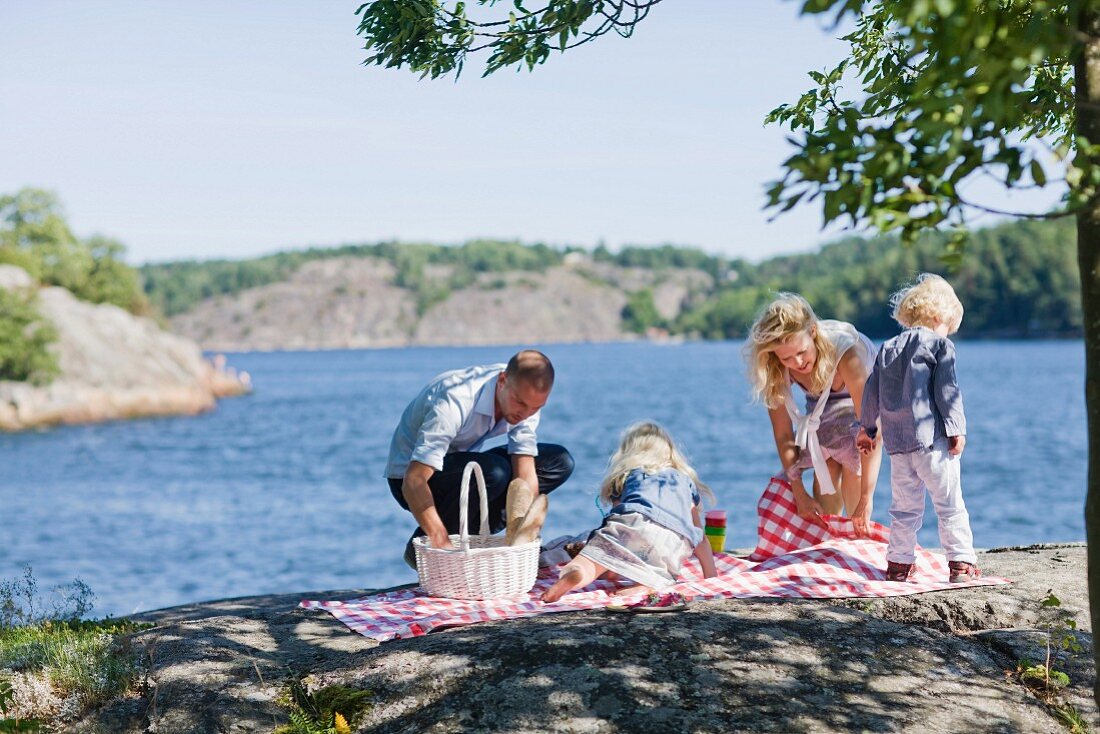 Junge Familie beim Picknick am See