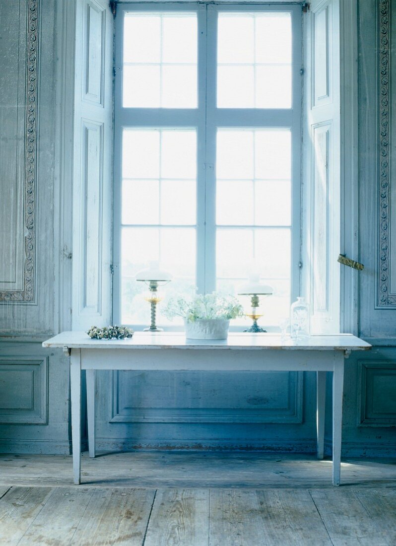 Simple console table below tall window in grand room