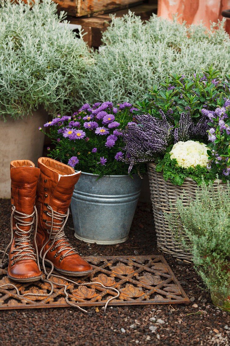 Autumnal planters in entrance area with boots on doormat