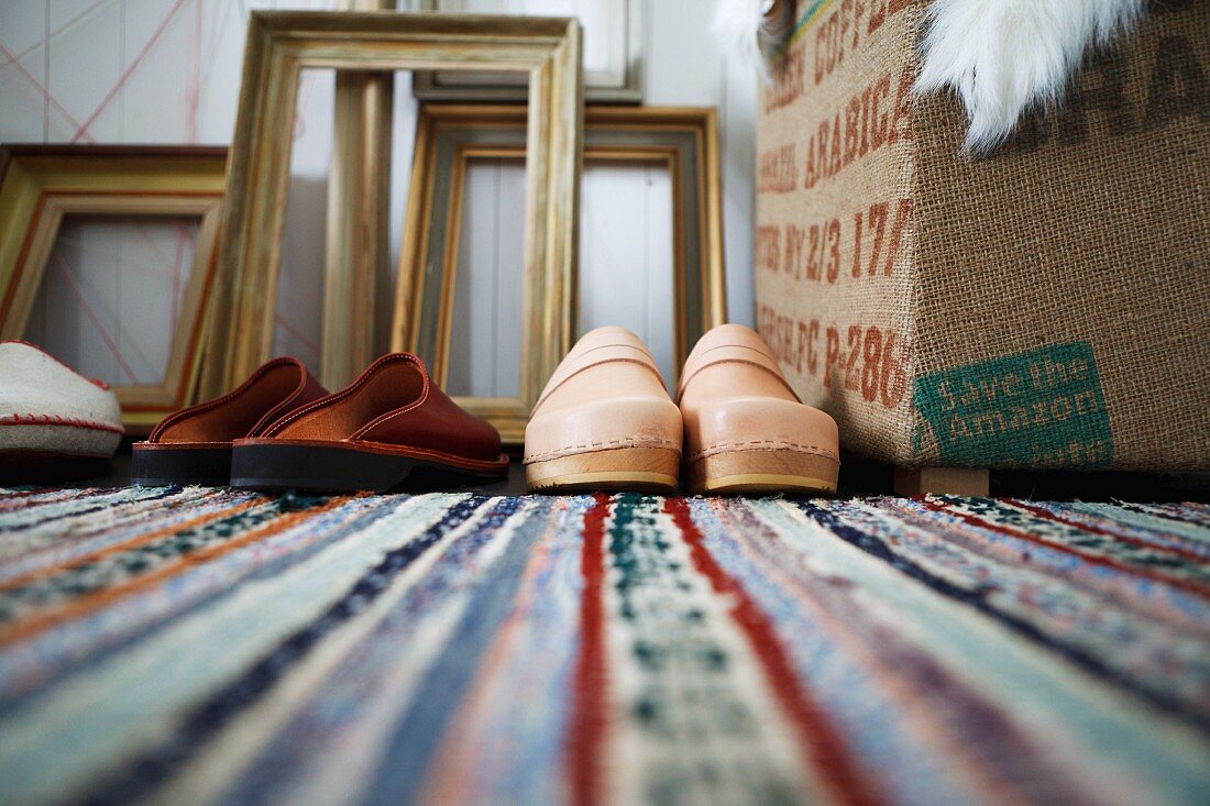 Slippers & clogs on rug (close-up)