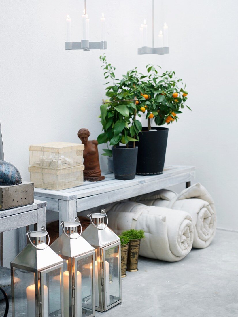 Weisser Wandtisch mit Topfpflanzen, einem Frauentorso und transparenten Aufbewahrungsschachteln
