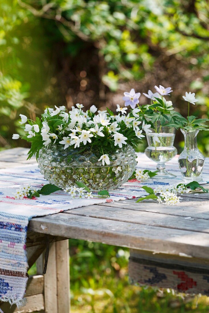 Buschwindröschen in Vasen auf Tisch im Freien