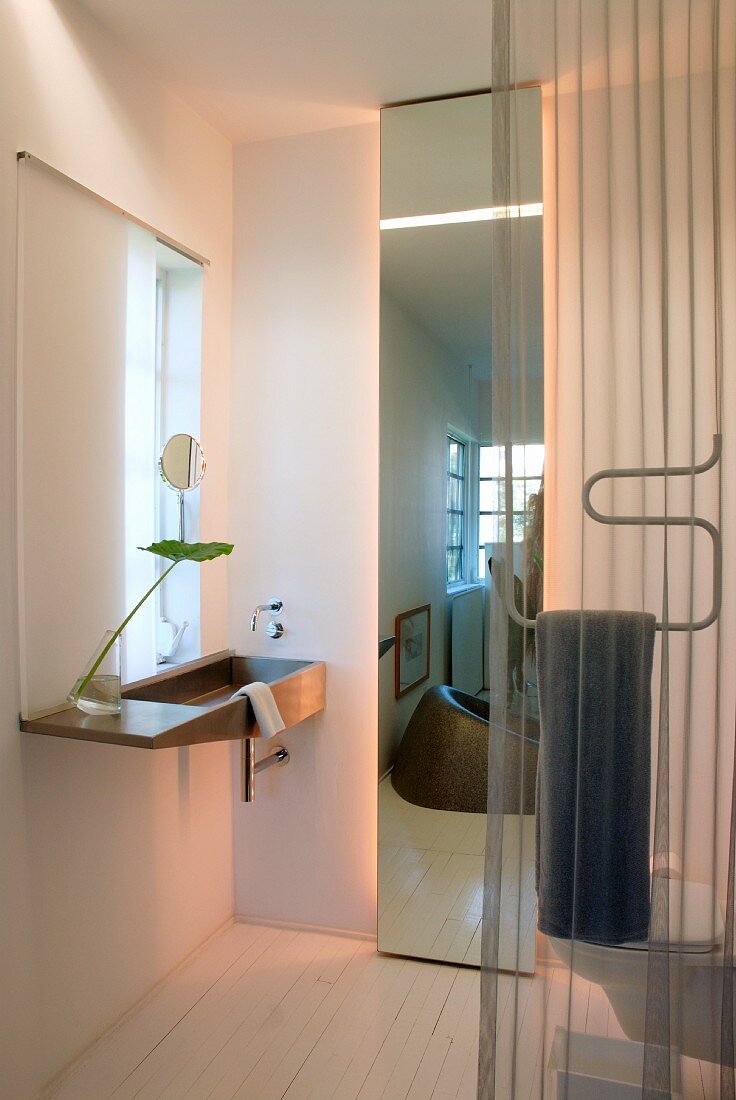Elegantes Designerbad mit Waschbecken und raumhohem Spiegel