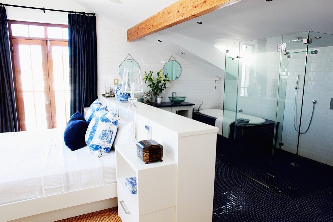 Weißes Schlafzimmer mit freiem Zugang zum Badezimmer mit gläserner Duschabtrennung