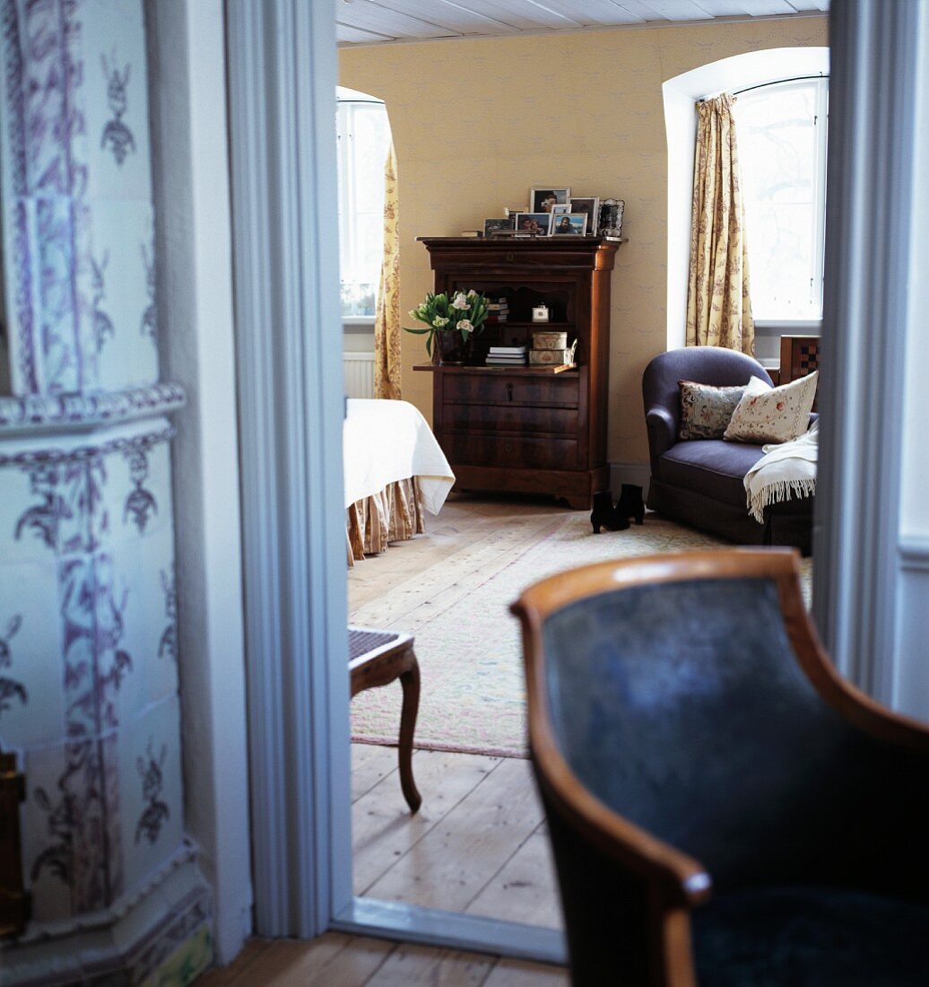 Blick in traditionelles Schlafzimmer mit antikem Sekretär und bequemer Recamiere