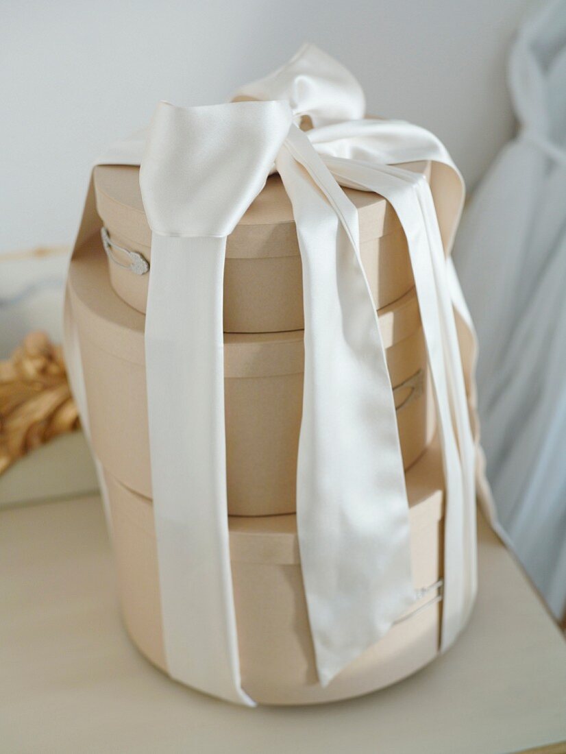 Three round gift boxes tied together with chiffon ribbon
