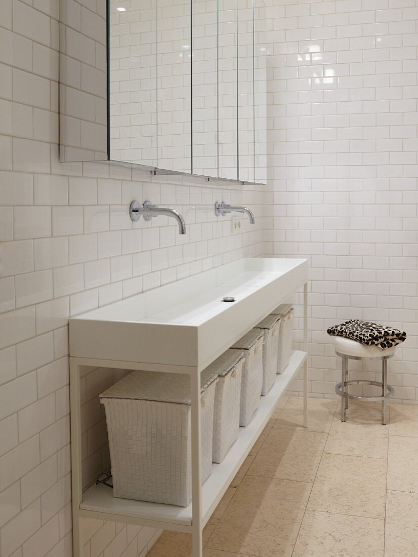 Long washstand with storage baskets and mirrored wall cabinets in white, minimalist bathroom