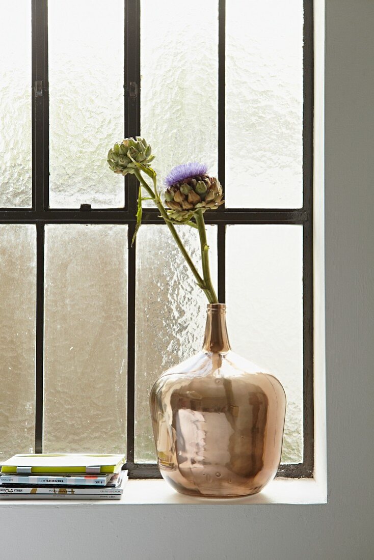 Glänzende Vase mit getrockneten Artischockenblüten