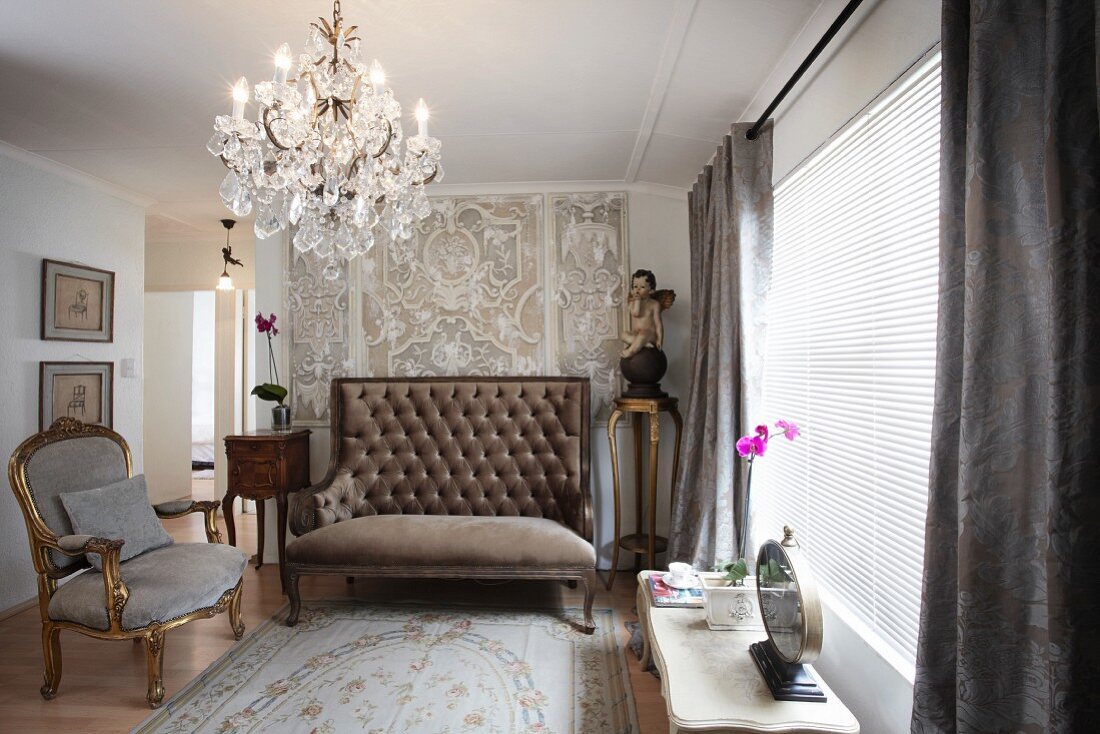 Goldener Rokoko Sessel und gepolsterte Sitzbank mit hoher Rückenlehne und Kronleuchter im Wohnzimmer
