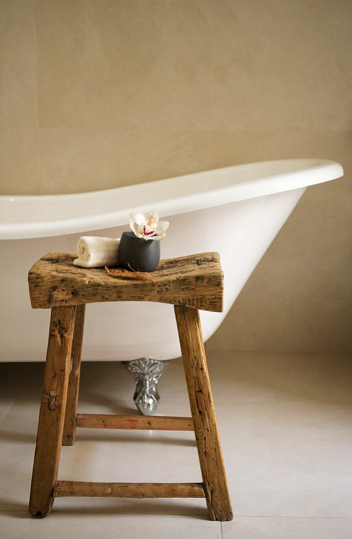 Free-standing, antique bathtub and rustic stool