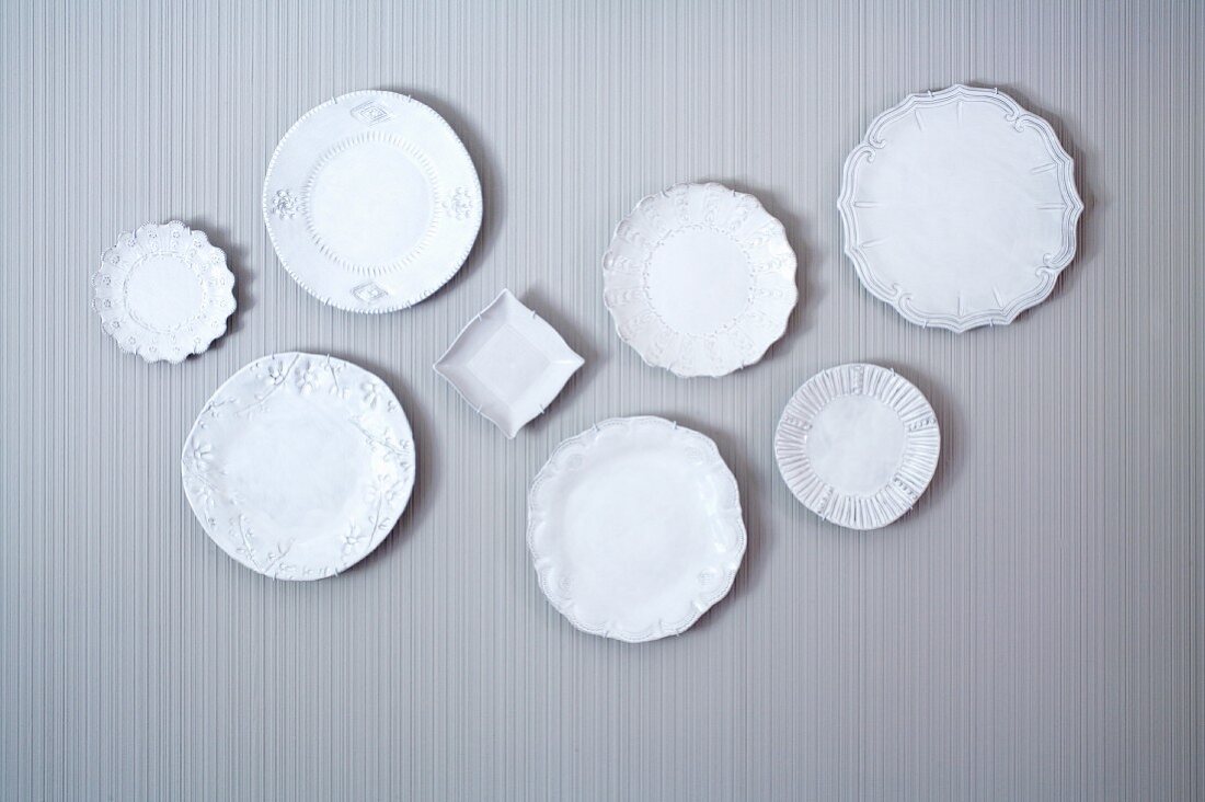 Collection of white china plates on wall