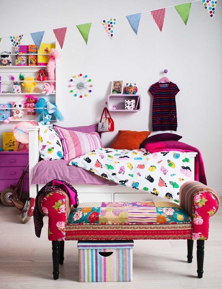 Colourful child's bedroom with bed, shelves and stool