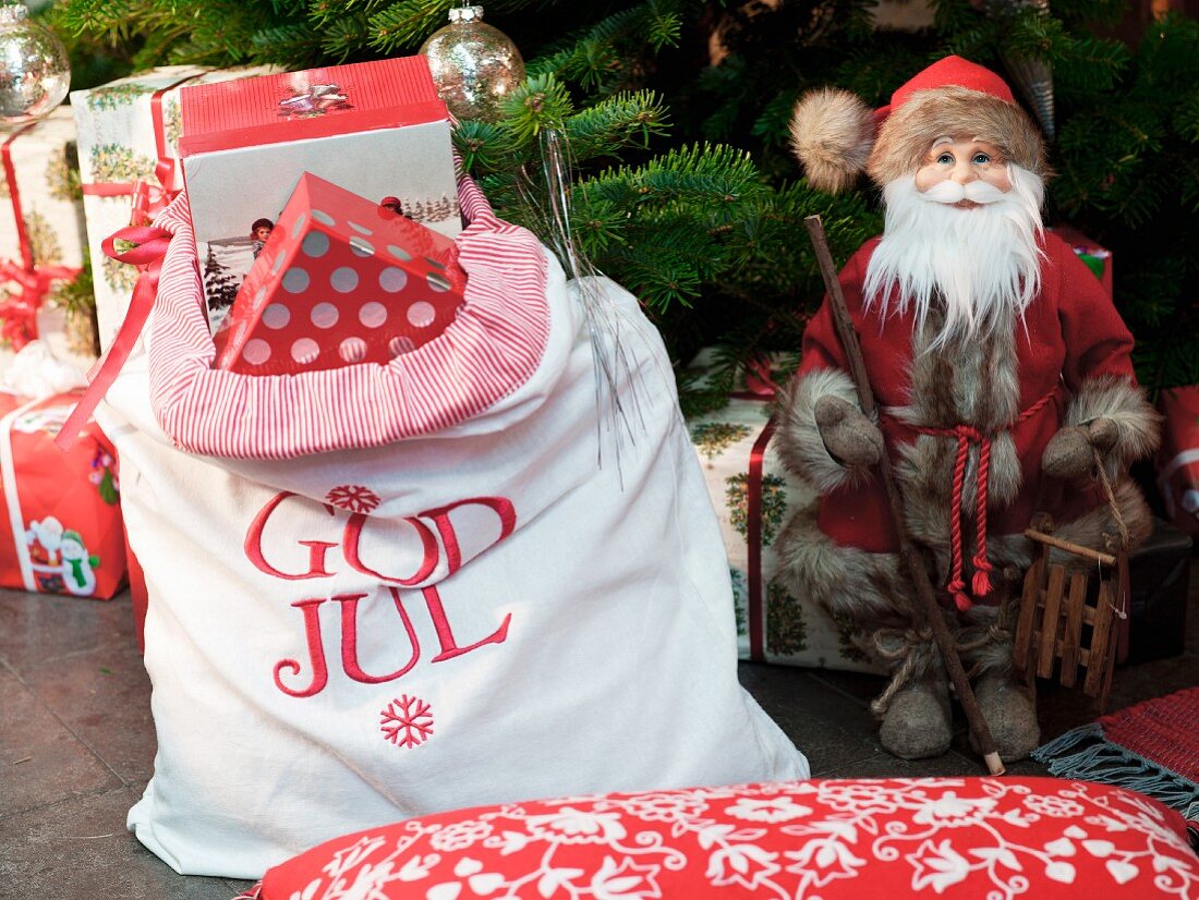 Father Christmas figurine & sack of presents under Christmas tree