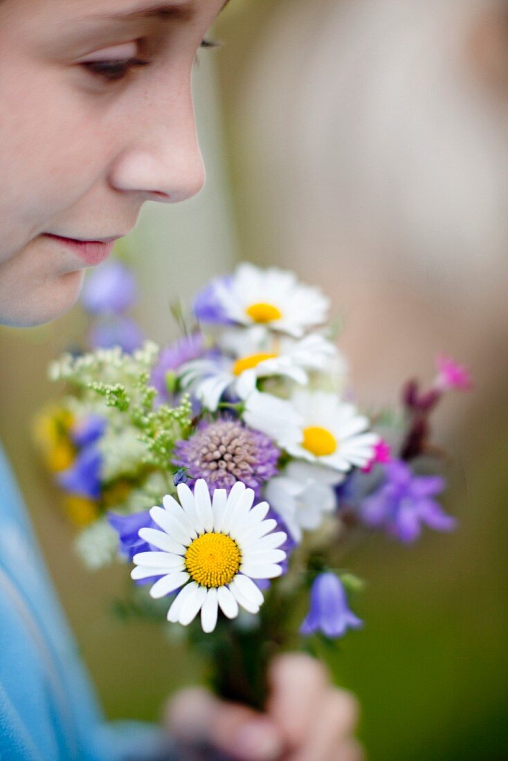 Mädchen hält einen Wiesenblumenstrauss (Nahaufnahme)