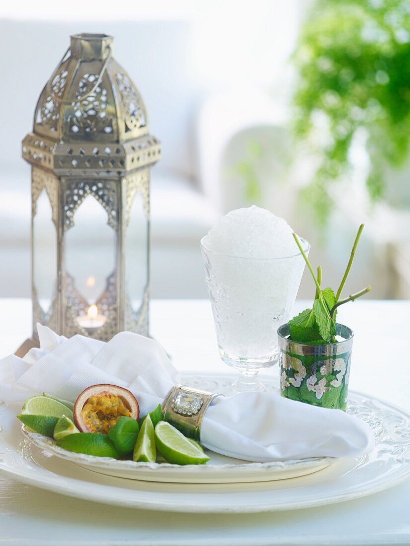 Oriental still-life arrangement of silver lantern, granita, peppermint and napkin in silver napkin ring