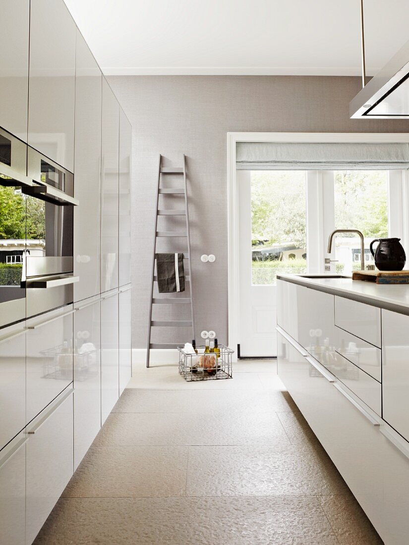 Moderne, helle Küche mit grauen Wänden und weissen Fronten