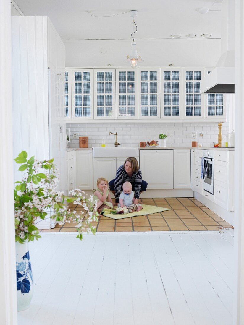Mother and children in white, Scandinavian-style kitchen