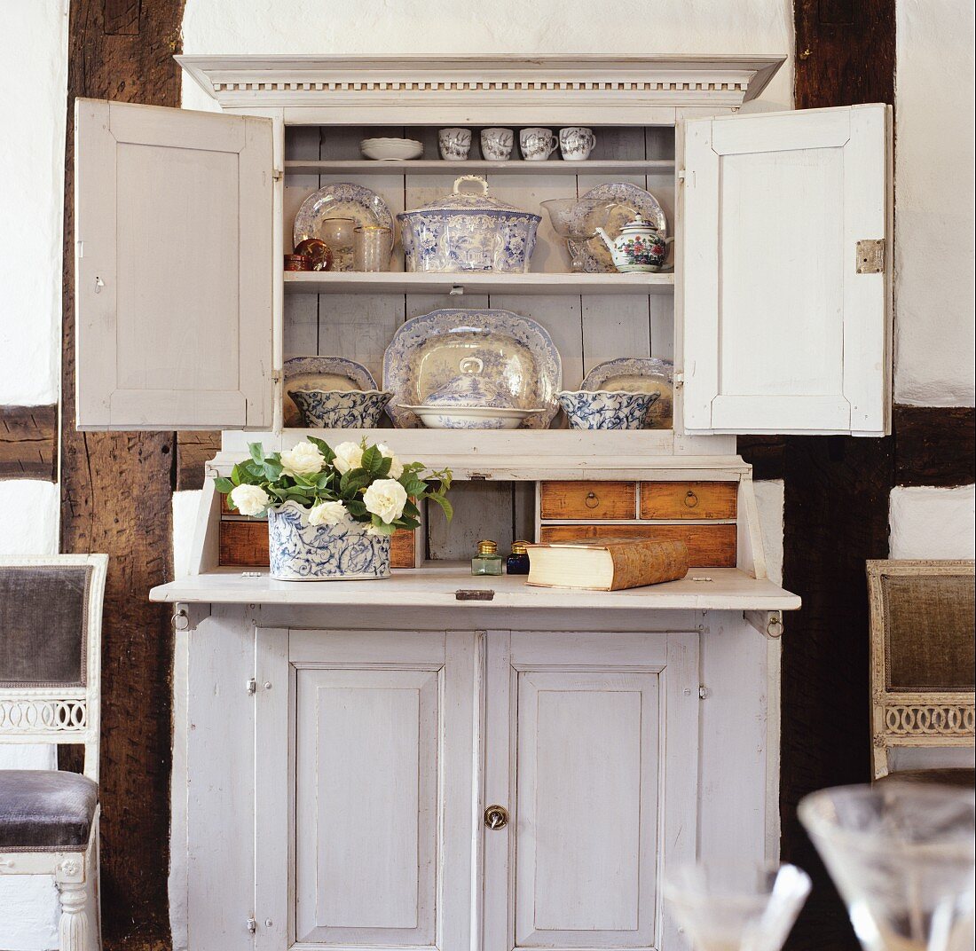 Blue and white crockery in old, white-painted dresser