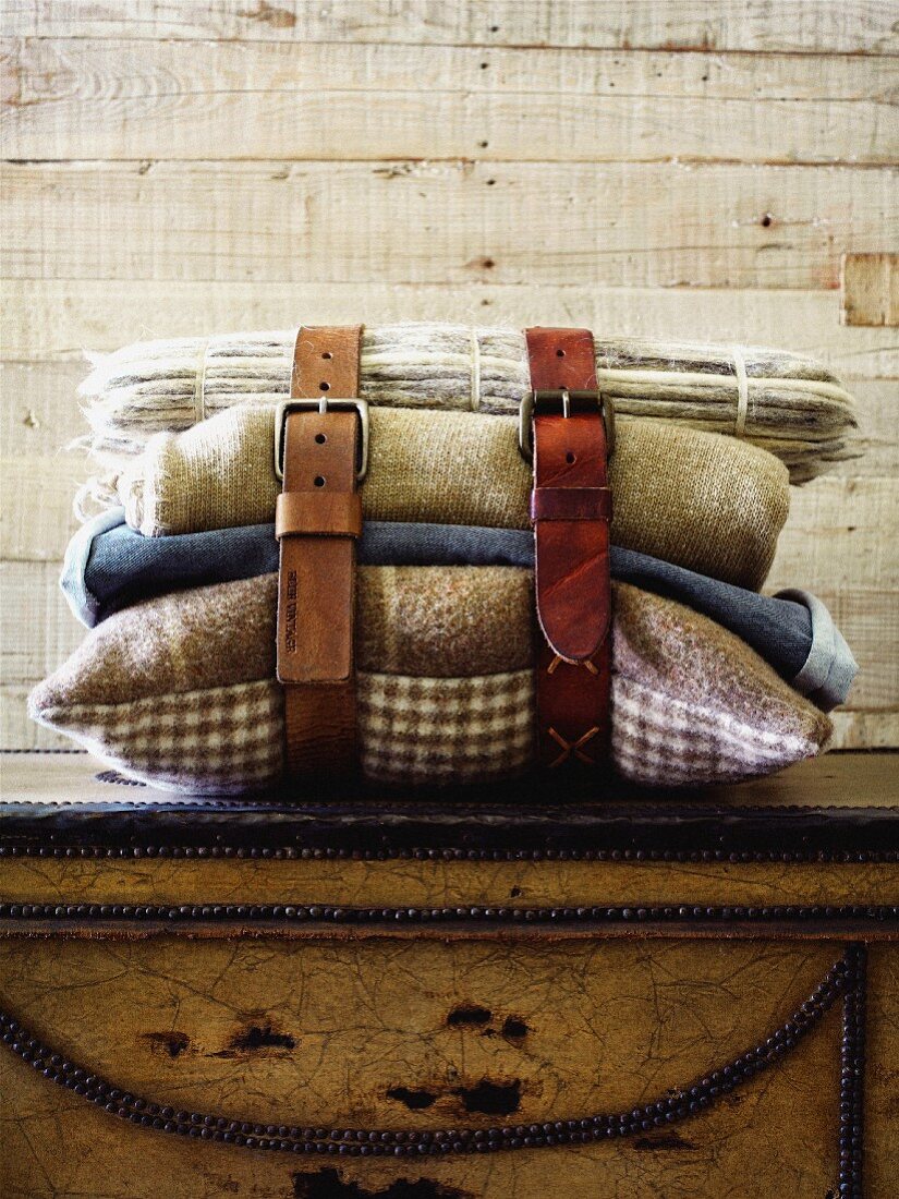 Leather belts buckled around cushions and blankets