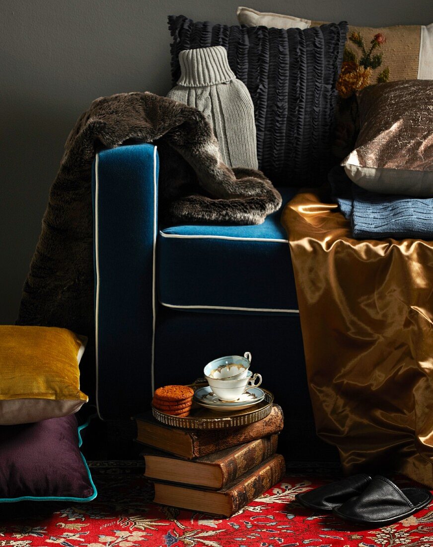 Collection of shiny fabrics and fur on armchair with blue upholstery