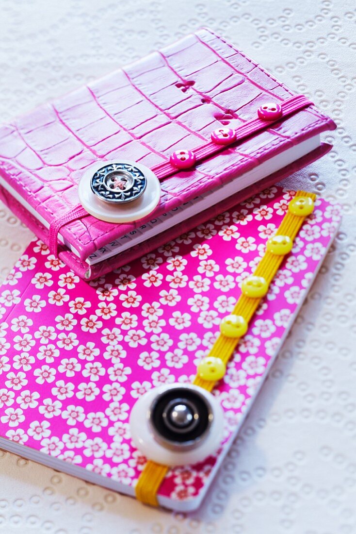 Elastic ribbons decorated with buttons on notebooks