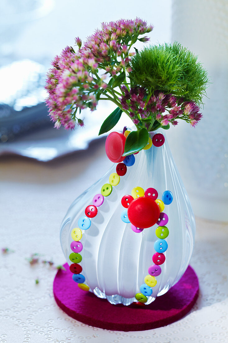 Vase decorated on outside with many small buttons