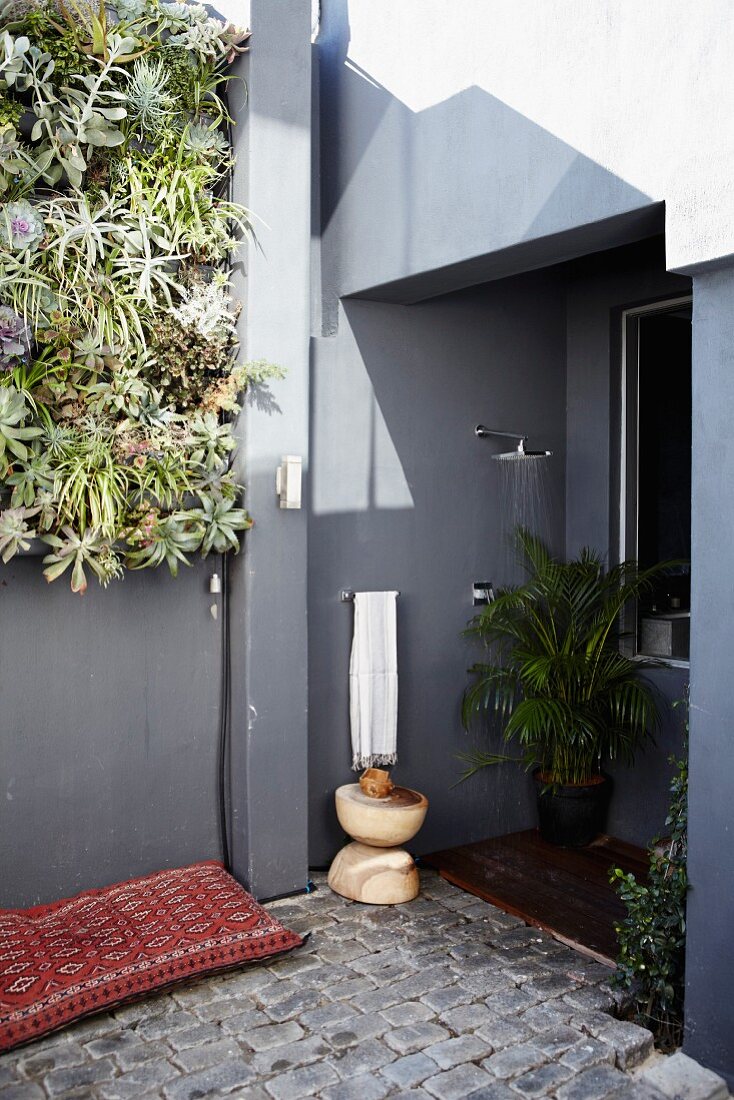 Corner of terrace with vertical planting and outdoor shower in niche