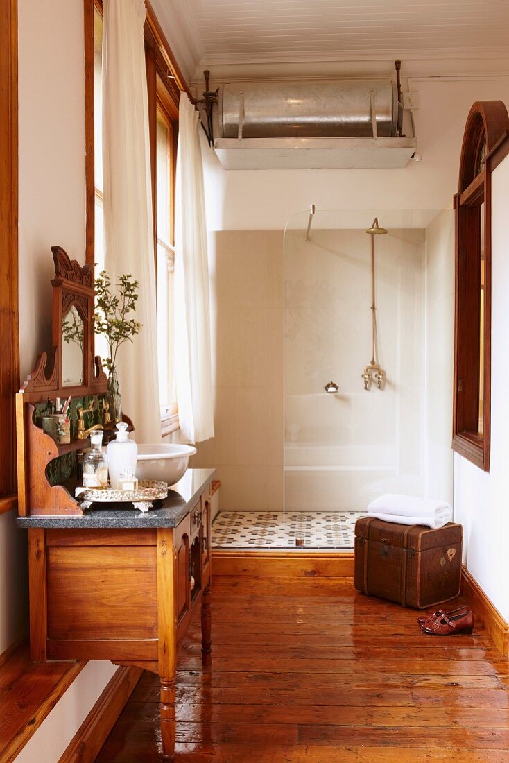 Separate bath area with wooden floor and tiled, floor-level shower