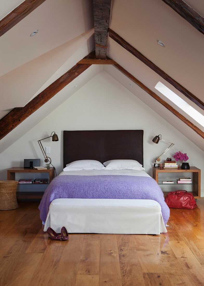 Modernes Schlafzimmer mit hellem Holzparkett und gemütlichem Doppelbett unter den Dachschrägen