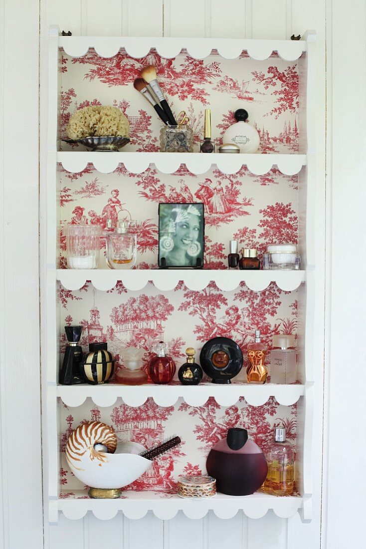 Plate rack with back lined in red and white toile de jouy wallpaper