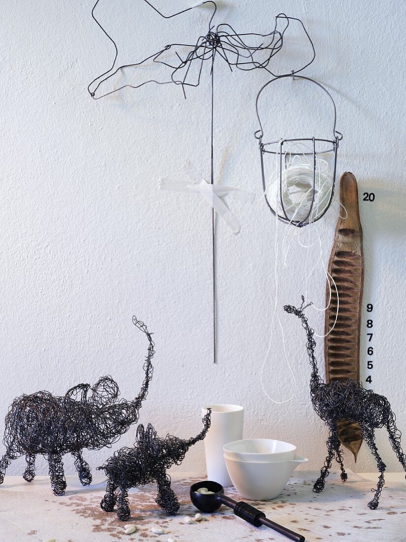 Safari-Tierfiguren aus schwarzem Draht vor weißer Wand mit Drahtobjekten