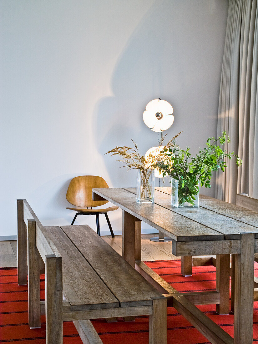 Rustic wooden table and bench in the dining room with white wall