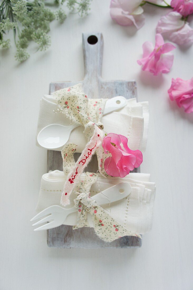 Linen napkins & cutlery decorated with ribbons & sweet peas